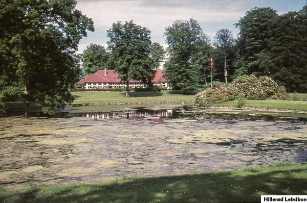 Slotspavillonen, nedbrændt i 1970, med Hesteskodammen i forgrunden.(Ukendt fotograf, postkort fra 1960-70, Lokalhistorisk Arkiv, Hillerød Bibliotek).
