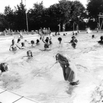Friluftsbadet ved Frederiksborg Byskole ca.1956. Lærer Vibeke Flarup underviser i svømning. ( Fotograf: Ukendt, Lokalhistorisk Arkiv, Hillerød Bibliotek)